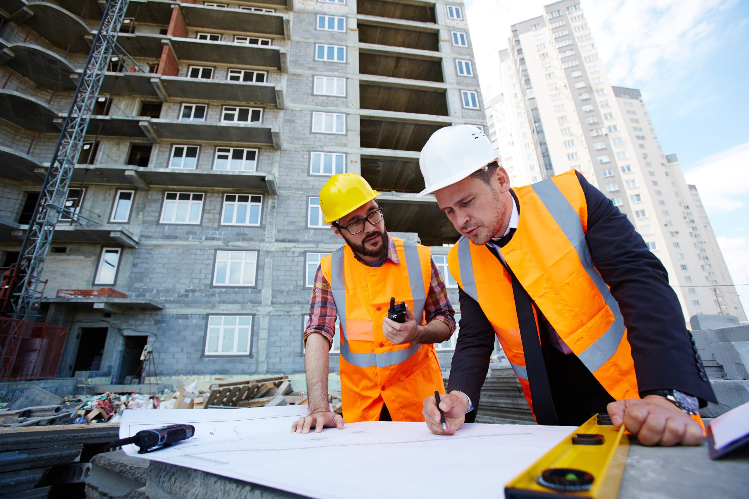 Construction site with project manager and builder discussing the project and deciding how to proceed.